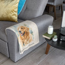 A golden retriever portrait blanket is draped over a gray armchair.