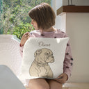 A woman holds an Oscar dog portrait pillow on a window seat.