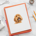 A dog portrait sticker decorates a white notebook on a marble desk.