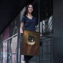 A woman holds a Royal / Renaissance cat portrait outside a dark building.