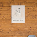 A line art memorial dog canvas hangs on a warm wood wall.