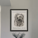 A framed memorial dog portrait hangs on a gray wall above flowers.